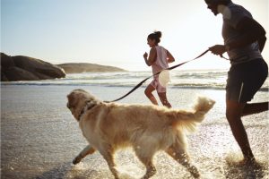 Couple-running-on-beach-dog-exercise